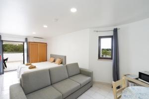 uma sala de estar com um sofá e uma cama em Apartamentos Vale de Carros by Umbral em Albufeira