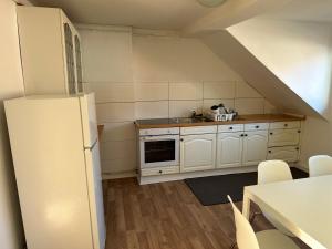 a kitchen with white cabinets and a white refrigerator at Apartment for rent 1 in Celle +5 photos