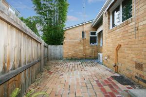 a brick walkway next to a building with a fence at Lisson Holiday Rental in Melbourne