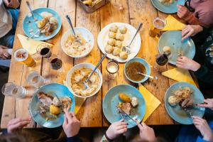 a group of people sitting around a wooden table eating food at Obiralmhütte Mosgan in Bad Eisenkappel +27 photos