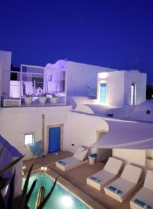 a villa with a swimming pool at night at Dar Bibine in Erriadh