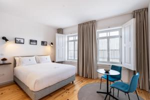 a bedroom with a bed and a table and chairs at LP Heritage Apartments next to Braga Cathedral by Sé Apartamentos in Braga