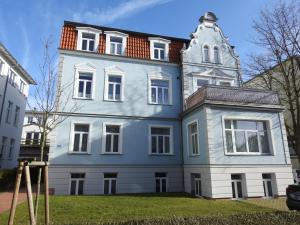 a blue and white house with a tower at Apartments in Warnemuende in Warnemünde