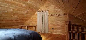 Les cabanes des Pierreux في Gesves: غرفة نوم مع سرير في كابينة خشب