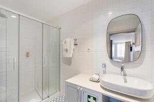 a bathroom with a sink and a shower and a mirror at LP Heritage Apartments next to Braga Cathedral by Sé Apartamentos in Braga +101 photos