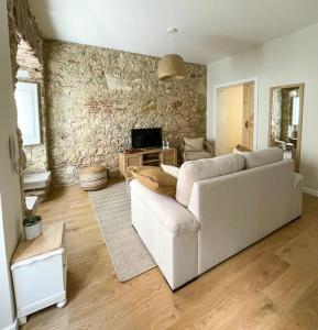 a living room with a white couch and a stone wall at Olivete Apartment in Lisbon