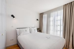 una camera con un letto bianco e una grande finestra di LP Heritage Apartments a Braga