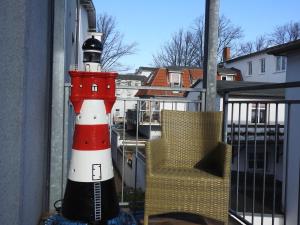 un faro en un balcón con una silla en Apartments in Warnemuende, en Warnemünde