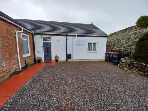 a house with a gravel driveway in front of it at Solway Retreat in Gretna