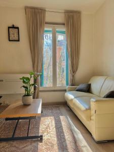 a living room with a couch and a table and a window at Sacré coeur de ville in Lunel