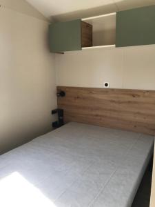 een kleine kamer met een bed en groene kasten bij Mobile-home Pin in Bec-de-Mortagne