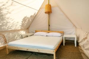 1 cama en una tienda de campaña con 2 almohadas en Calacavallo Village en San Teodoro