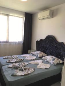 a bedroom with a bed with blankets and pillows at Луксозни апартаменти под наем в комплекс Грийн Лайф Созопол in Duni
