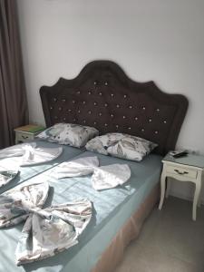 an unmade bed with a headboard and two pillows at Луксозни апартаменти под наем в комплекс Грийн Лайф Созопол in Duni