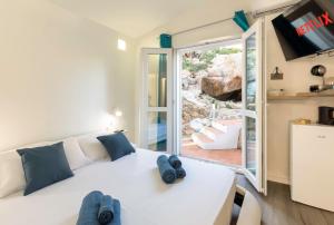 a bedroom with a white bed and a sliding glass door at Villa Esmeralda - Free Wifi - with swimming pool in Costa Paradiso