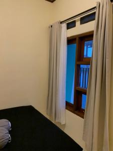 een slaapkamer met een bed en een raam bij First Tasnim Village in Cibatok 1