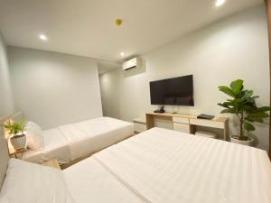 pokój hotelowy z 2 łóżkami i telewizorem z płaskim ekranem w obiekcie Vu Gia Hotel Phu Quoc w Duong Dong