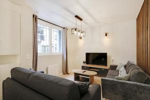 sala de estar con 2 sofás y TV en Pick A Flat's Apartment in La Chapelle - Impasse du Curé en París
