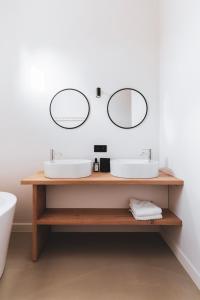 uma casa de banho com dois lavatórios e dois espelhos em Duisbeke Logies em Oudenaarde