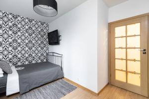 Schlafzimmer mit einem Bett mit einer schwarz-weißen Wand in der Unterkunft SuperApart Żytnia 16 in Warschau