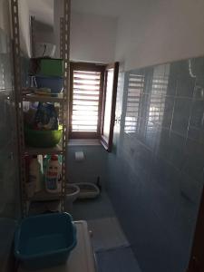een badkamer met een toilet en een raam bij Appartamento incantevole con parcheggio custodito in Roccella Ionica