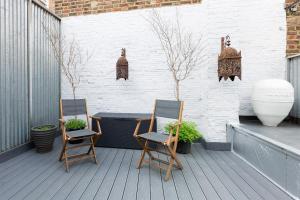 a patio with two chairs and a table on a deck at Stunning flat in Notting Hill with roof top in London