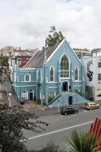 a blue church on the side of a street at Chapel Apartment in Dunedin