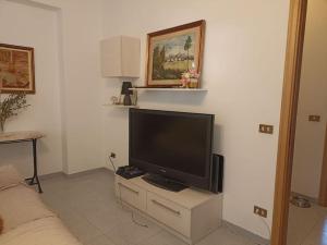 een woonkamer met een flatscreen-tv op een standaard bij Appartamento incantevole con parcheggio custodito in Roccella Ionica