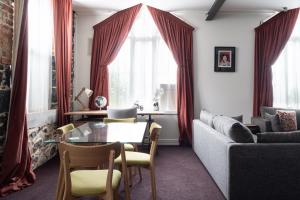 sala de estar con mesa y sofá en Chapel Apartment, en Dunedin