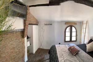 um quarto com uma cama e uma parede de tijolos em Cœur de ville em Perpignan
