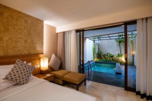 a bedroom with a bed and a room with a swimming pool at Cross Vibe Paasha Atelier Bali Kuta in Kuta +47 photos
