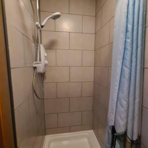 a shower with a shower head and a shower curtain at Sheridan House - En-suite Bedrooms I Long or Short Stay I Special Rate Available in Derby