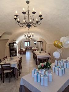 a dining room with tables and chairs and a chandelier at Il pozzo dei desideri in Castelnuovo