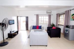 uma sala de estar com um sofá branco e uma televisão em ARO APARTMENTS: (College Road) em Lagos