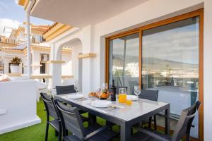 una mesa con sillas y copas de vino en el balcón en PaulMarie Family Apartment Ocean&Mountain View, en Adeje