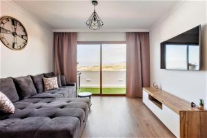 a living room with a couch and a large window at PaulMarie Family Apartment Ocean&Mountain View in Adeje