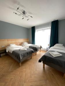 a room with three beds and a large window at Willa K52 in Siemiatycze