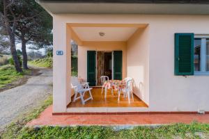 een huis met een tafel en stoelen op een veranda bij Appartamenti Campo al Pero - Goelba in Casa Leonardi