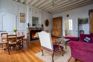 ein Wohnzimmer mit einem lila Sofa und einem Tisch in der Unterkunft Demeure Jousset des Berries in Le Mans