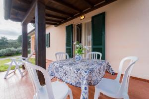 een tafel en stoelen op de veranda van een huis bij Appartamenti Campo al Pero - Goelba in Casa Leonardi