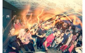 a group of people posing for a picture in a room at Nangijala Hostel in Disentis