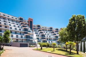 ein großes Apartmenthaus mit Palmen davor in der Unterkunft Penthouse Paradisus by LovelyStay in Caniço
