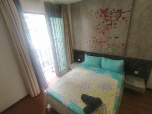 Un dormitorio con una cama con almohadas azules y flores. en [SLEEPS 4 PAX] @ I-CITY en Shah Alam