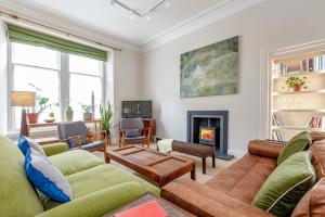 a living room with couches and a fireplace at Murray Place - 5 min walk from The Old Course in St Andrews