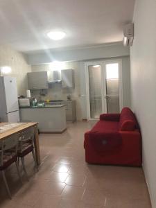 a living room with a red couch and a kitchen at Villa G.Giuliano in Floridia +34 photos