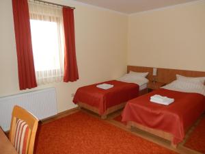 a hotel room with two beds and a window at Frittmann Borház in Soltvadkert