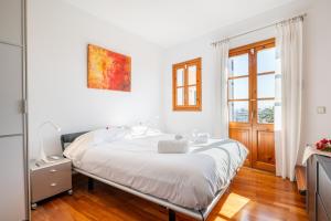 a white bedroom with a bed and a window at Moli 37 House - Port View Terrace in Palma de Mallorca