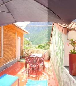 Un patio con sillas y una mesa en el balcón. en Chalet Juana La Concha Valle de Agaete, en San Pedro