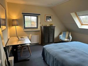 a bedroom with a bed and a desk and a desk at Holiday Home Stavoren by Interhome in Stavoren