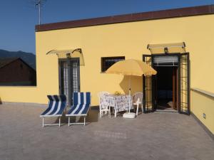 eine Terrasse mit Tisch und Stühlen und einem Sonnenschirm in der Unterkunft Holiday Home Lavanda - AEG160 by Interhome in Albenga